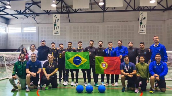 Imagem dos atletas das duas seleções perfilados com as duas bandeiras na mão.